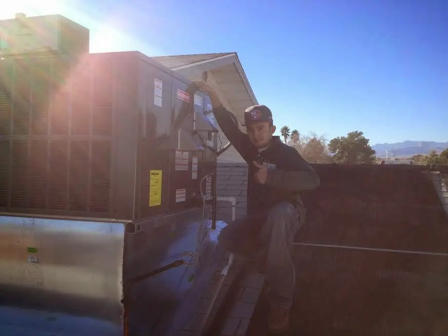 HVAC technician performing Boiler Repair on a rooftop unit in Westford